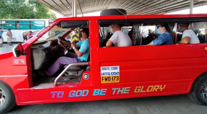 Commuters onboard a jeepney wear face shields and facemasks as protection against the spread of coronavirus. The government is reducing physical distancing in public transportation to help the public transport sector recover from the slump caused by lockdown measures. But several mayors in Iloilo province fear this move could increase the risk of virus transmission. IAN PAUL CORDERO/PN