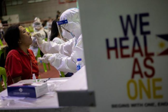 A woman gets a free coronavirus disease swab testing at a gymnasium in Navotas City, Metro Manila on Aug. 7, 2020. ELOISA LOPEZ/REUTERS