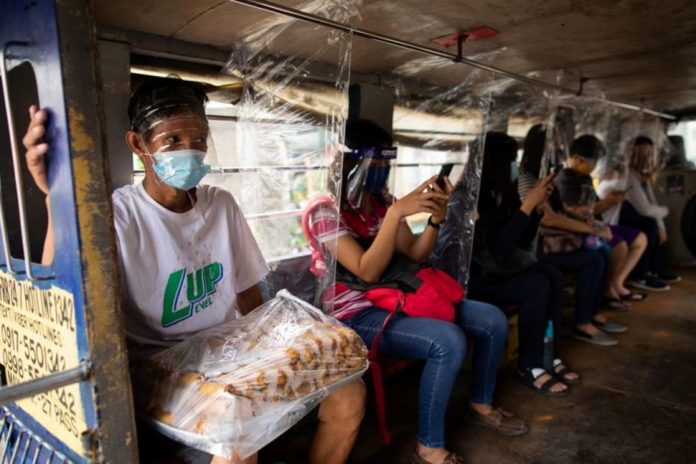 Jeepney passengers seated between plastic barriers, wear face masks and face shields mandatory in public transportation, to help curb coronavirus infections, in Quezon City, Metro Manila on Aug. 19, 2020. ELOISA LOPEZ/REUTERS