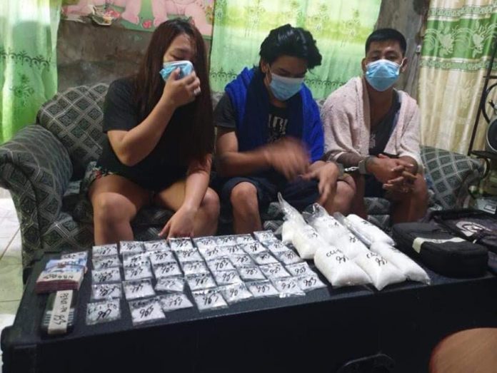 SHABU HAUL. Drug suspects Carline Lunares, Nester Brinosa and Richard Lunares cover their faces with masks while the inventory of suspected shabu seized from them on Sept. 29, 2020 is ongoing in Barangay Handumanan, Bacolod City. PRO-6 PHOTO