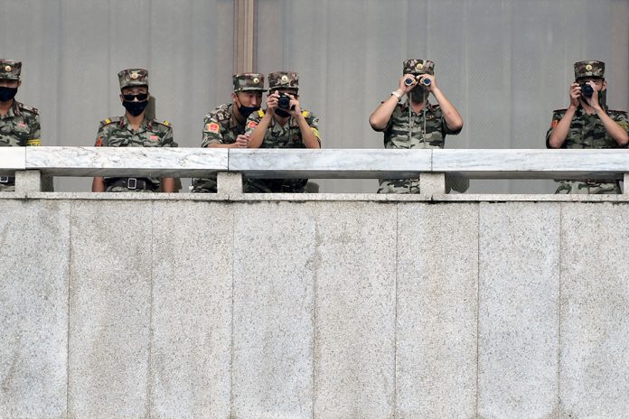 North Korean soldiers keep watch toward the south as South Korean Unification Minister Lee In-young inspects (not pictured) the truce village of Panmunjom inside the demilitarized zone separating the two Koreas. KOREA POOL/REUTERS