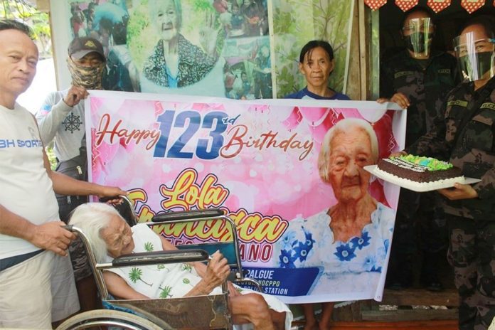 Policemen in Kabankalan City, Negros Occidental led by Lieutenant Colonel Mary Rose Pico (right) greet Francisca Montes-Susano, who turned 123 years old on Sept. 11, 2020 at her residence in Barangay Oringao. The super-centenarian was tagged the oldest living Filipino and could also be the world’s oldest once her birth records are verified. KABANKALAN CITY POLICE STATION