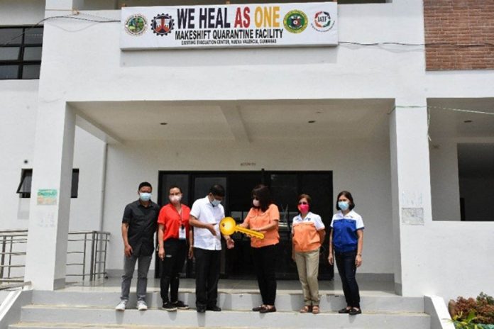 DPWH 6 Regional Director Lea Delfinado (third from right) gives the symbolical key to Nueva Valencia Mayor Emmanuel Galila to officially turn over the quarantine facility to the local government unit. Photos by M. Sedicol and S. Jimenez