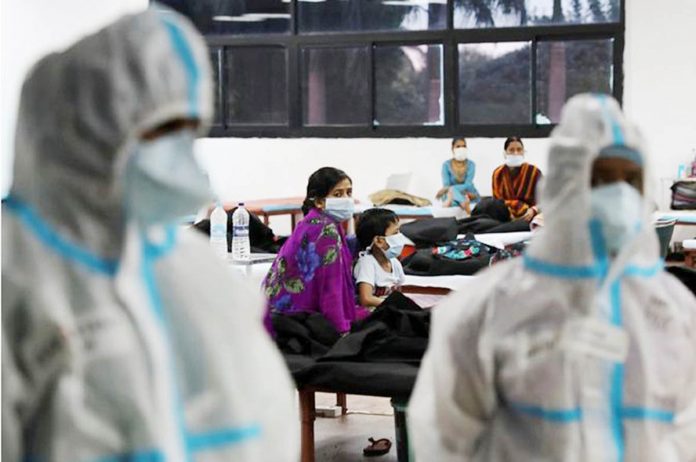 A woman sits with her child inside a quarantine center for COVID-19 patients amidst the spread of the disease at an indoor sports complex in New Delhi, India, September 22, 2020. REUTERS