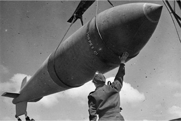 A 12,000-lb MC deep-penetration bomb is hoisted from the bomb dump to its carrier at Woodhall Spa, Lincolnshire