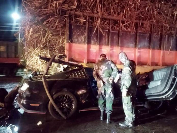 Policemen inspect this mangled Ford Mustang pinned under a 10-wheeler truck along the Circumferential Road in Barangay Villamonte, Bacolod City around 1 a.m. on Oct. 13, 2020. BCPO