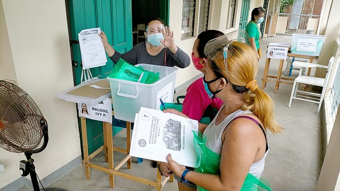 Wearing face shields and masks, parents claim the learning modules of their children at Jalandoni Memorial High School in Iloilo City on Friday. Classes in public elementary and high schools nationwide begin on Oct. 5 for school year 2020-2021. IAN PAUL CORDERO/ PN