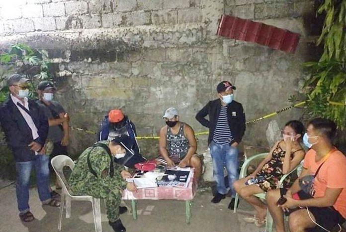 Antidrug operatives conduct an inventory of illegal drugs seized from Eliza May Malfarta (second from right) and Distin Jay Garvelles (fourth from left) in a buy-bust in Zone 3, Barangay Boulevard, Molo, Iloilo City on Oct. 19, 2020. PRO-6