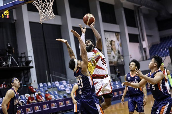 San Miguel Beermen’s Moala Tautuaa scores against the defense of Negrense Reynel Hugnatan of Meralco Bolts. PBA PHOTO