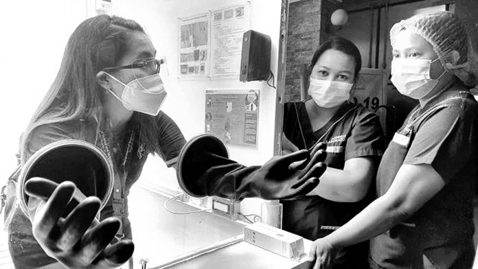 Healthcare workers of Angel Salazar Memorial General Hospital in San Jose, Antique check this “no-contact” specimen collection booth they would use to swab people. PIA-6 Photo