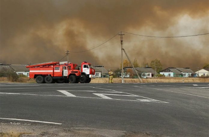 Fire trucks are seen on the road as smoke rises from the site of a fire at an ammunition depot in Ryazan Region, Russia Oct. 7, 2020. RUSSIAN EMERGENCIES MINISTRY IN RYAZAN REGION/HANDOUT VIA REUTERS