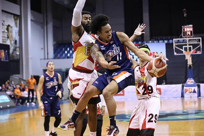 Meralco Bolts’ Chris Newsome looks to pass the ball after being cornered by San Miguel Beermen’s Arwind Santos and Moala Tautuaa. PBA PHOTO