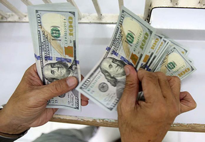 A man counts dollar remittances at a money changer in United Nations Avenue in Manila. PHOTO BY RUSSELL PALMA