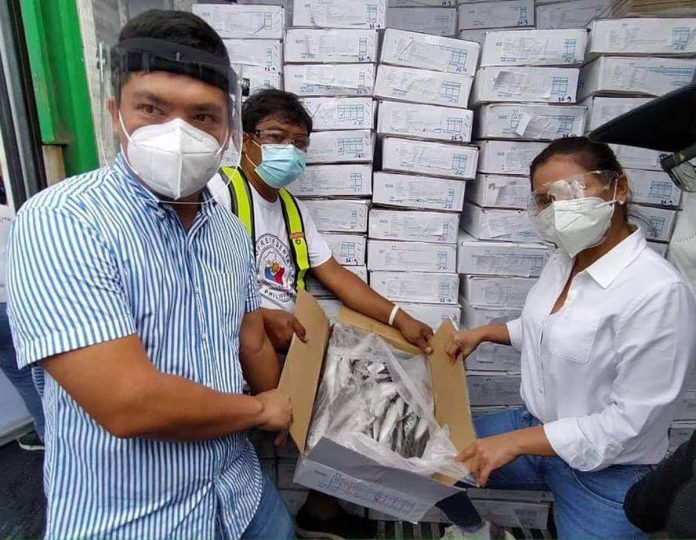 Iloilo City’s Cong. Julienne Baronda (right) and Miguel Treñas, representing his father Mayor Jerry Treñas, prepare these boxes of blast-chilled fish for distribution to poor households. The fish shipment arrived at the port of Iloilo City yesterday. IAN PAUL CORDERO/PN