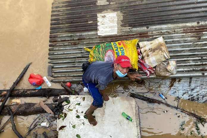 A resident of San Mateo Road, Rizal climbs on top of a roof amid the onslaught of typhoon Ulysses on Thursday, Nov. 12, 2020. JUN SEPE/ABS-CBN NEWS