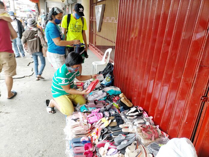 This vendor of plastic and rubber slippers on the sidewalk of Iznart Street, Iloilo City has to relocate elsewhere. The city government’s Public Safety and Transportation Management Office is again clearing the roads of obstruction starting Nov. 17. IAN PAUL CORDERO/PN