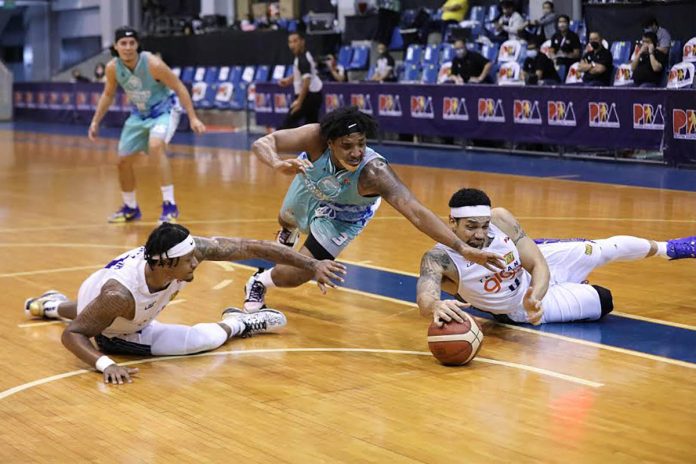 Phoenix Super LPG Fuel Masters’ Jason Perkins tries to grab the ball from the fallen TNT Tropang Giga Harvey Carey. PBA PHOTO