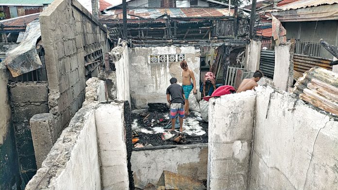 Residents sift through the ruins of their homes, looking for any recoverable belongings after a fire struck Zone 6-B in Barangay Boulevard, Molo, Iloilo City on Christmas eve.