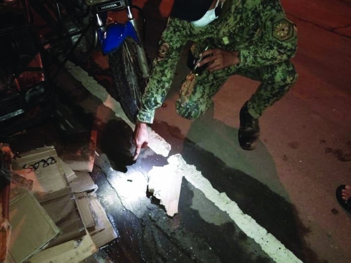 A police officer points to a spent bullets of a .45-caliber gun recovered after a shooting incident on Rizal Street, Barangay 9, Kabankalan City, Negros Occidental on Dec. 11. CONTRIBUTED PHOTO