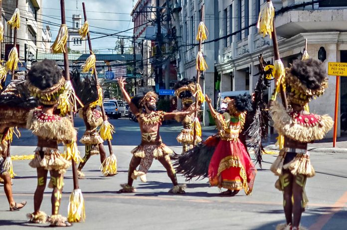 PRE-FILMED PERFORMANCE. Tribu Bariohanon “warriors” hit Iloilo City’s Mapa and Rizal streets Thursday afternoon during the shooting of their “pre-filmed” performance for Digital Dinagyang Festival 2021. This would be streamed on social media accessible to spectators the world over. IAN PAUL CORDERO/PN