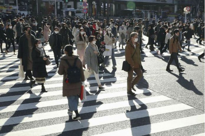 Passersby wearing protective face masks walk on the Shibuya crossing amid the COVID-19 outbreak in Tokyo, Japan on Dec. 26, 2020. KYODO/REUTERS