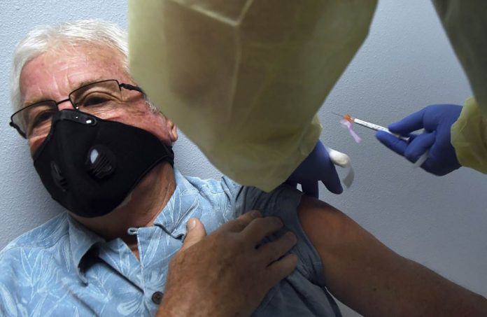 A participant gets a shot during a COVID-19 vaccine clinical trial sponsored by Moderna. PAUL HENNESSY/AP