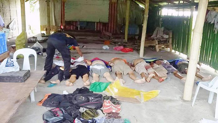 REBELS OR NOT? A policeman checks the bodies of suspected New People’s Army rebels killed in a predawn gunfight in Barangay Atabay, San Jose, Antique on Aug. 15, 2018. PN FILE PHOTO