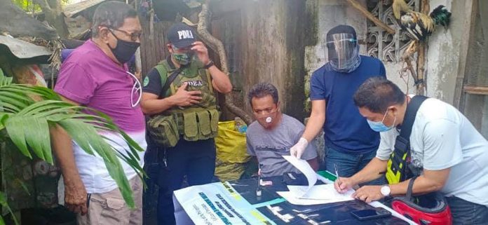 Antidrug operatives conduct an inventory of illegal drugs seized from Joselito Lumbrino (seated) during an entrapment in San Carlos City, Negros Occidental on Nov. 30. PDEA-6