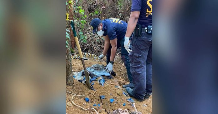 Scene of the Crime Operatives check the body of suspected New People’s Army rebel Randy Garsola buried in a shallow grave in Barangay Riverside, Isabela, Negros Occidental on Dec. 2. ISABELA POLICE STATION