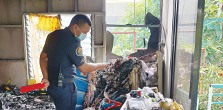 An arson investigator inspects the living room of a fire-hit house owned by the Majometano family in Barangay Sooc, Arevalo, Iloilo city on Jan. 5. IAN PAUL CORDERO/PN