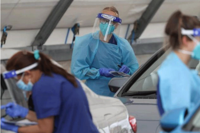 Medical workers administer tests at the Bondi Beach drive-through COVID-19 testing center in the wake of an outbreak in Sydney, Australia on Dec. 22, 2020. LOREN ELLIOTT/REUTERS