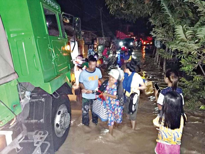 WET START FOR 2021. Police officers assist residents seeking evacuation after flashfloods hit 12 villages in Victorias City, Negros Occidental on New Year’s Eve. Thousands were forced to flee their inundated homes as torrential rain triggered floods in some parts of the province. CONTRIBUTED PHOTO