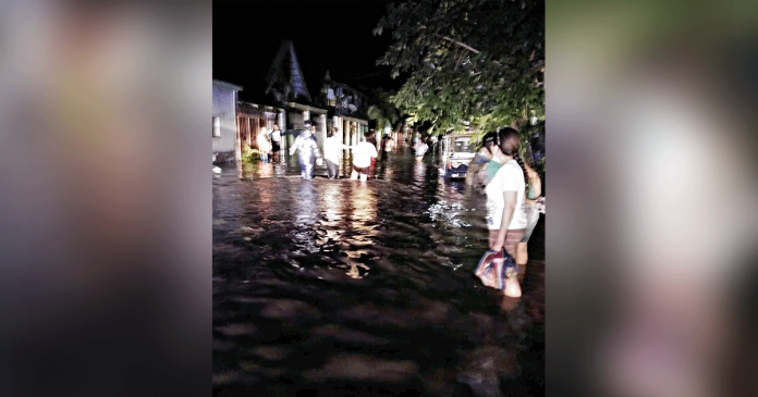 Residents wade through knee-deep flood to go to evacuation centers in San Carlos City, Negros Occidental. A heavy downpour lasting three hours on Saturday resulted in the flooding of at least five barangays in the city. SAN CARLOS PIO