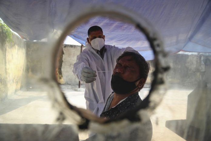 A health worker takes a nasal swab sample at a COVID-19 testing center in Hyderabad, India on Jan. 2, 2021. MAHESH KUMAR A./AP PHOTO