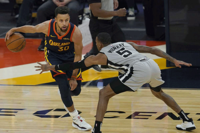 Golden State Warriors guard Stephen Curry is defended by San Antonio Spurs guard Dejounte Murray during the first half of an NBA basketball game in San Francisco, United States on Jan. 20, 2021. JEFF CHIU/AP PHOTO