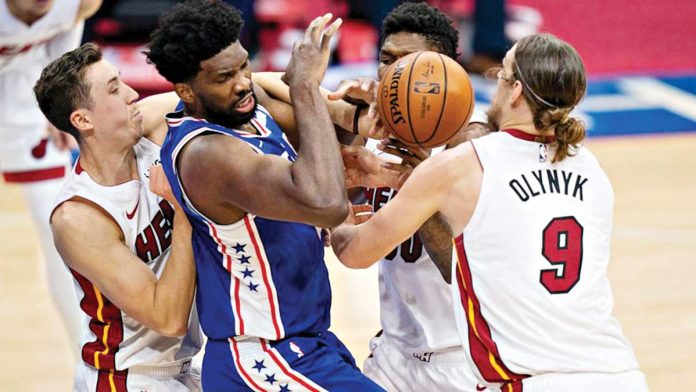 Philadelphia 76ers’ Joel Embiid is clobbered by the defense of three Miami Heat players. AP PHOTO