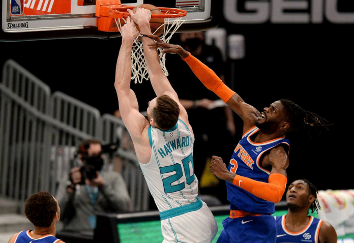 Charlotte Hornets forward Gordon Hayward throws down a two-handed dunk as New York Knicks center Nerlens Noel applies defensive pressure. JEFF SINER/CHARLOTTE OBSERVER