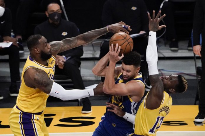 Los Angeles Lakers’ LeBron James and Dennis Schroder defend against Golden State Warriors’ Stephen Curry during the second half of an NBA basketball game on Jan. 18, 2021. JAE C. HONG/AP PHOTO