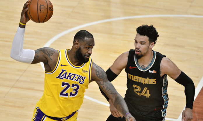 Los Angeles Lakers forward LeBron James handles the ball against Memphis Grizzlies guard Dillon Brooks in the second half of an NBA basketball game on Jan. 5, 2021 in Memphis, Tennessee, United States. BRANDON DILL/AP PHOTO