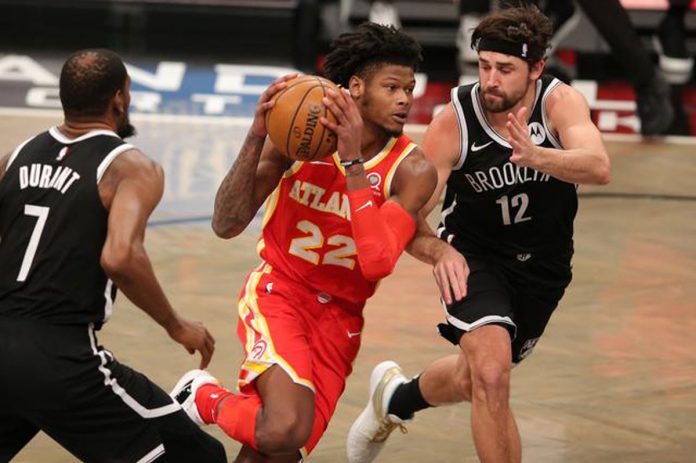 Atlanta Hawks small forward Cam Reddish drives the ball against Brooklyn Nets small forward Kevin Durant and shooting guard Joe Harris during the first quarter at Barclays Center. USA TODAY SPORTS