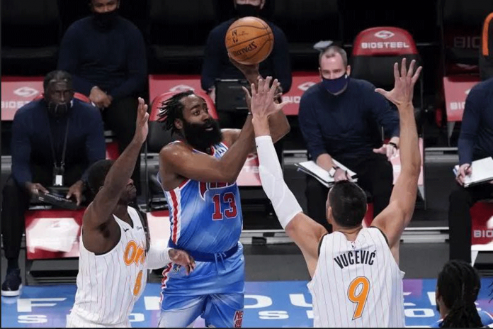 Brooklyn Nets guard James Harden is defended by two Orlando Magic players. PHOTO BY MARY ALTAFFER/AP