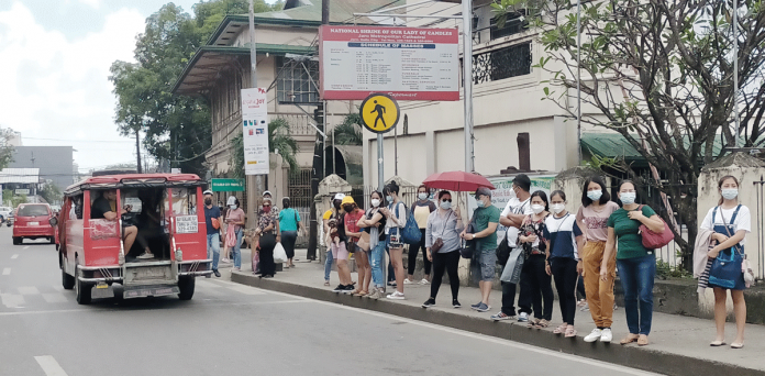 MANY PASSENGERS, TOO FEW JEEPNEYS Masked people wait for passenger jeepneys in Jaro, Iloilo City. Due to the coronavirus pandemic, not all jeepney drivers are keen on returning to the streets. IAN PAUL CORDERO/PN