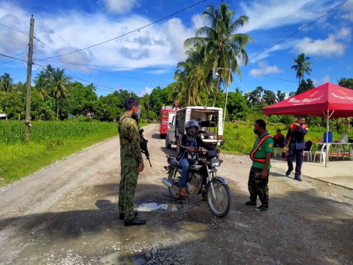 Policemen of Numancia, Aklan flags down a motorist in Sitio Ilaya, Barangay Aliputos. The sitio is on lockdown due to coronavirus disease. PHOTO NUMANCIA AKLAN PNP