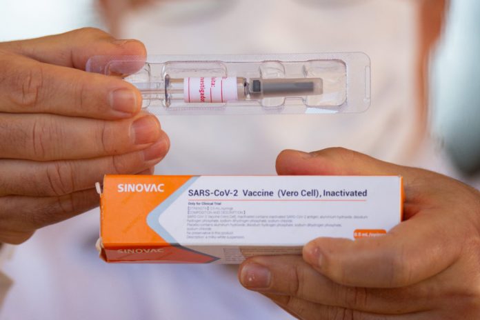 A professor at the University of Brasilia shows the vaccine to journalists amidst the coronavirus pandemic on Aug. 5, 2020 in Brazil. ANDRESSA ANHOLETE/GETTY IMAGES