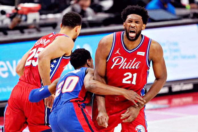 Philadelphia 76ers center Joel Embiid grimaces after Detroit Pistons guard Josh Jackson ran into him while chasing guard Ben Simmons during the first half of an NBA basketball game on Jan. 23, 2021. CARLOS OSORIO/AP