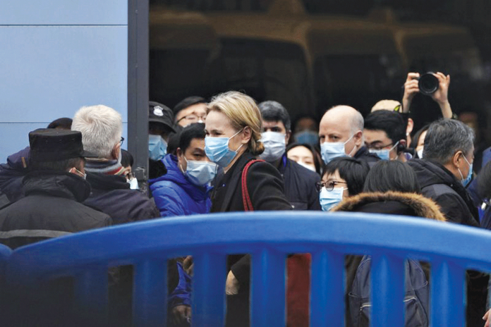 The World Health Organization team is briefed outside the Huanan seafood market on the third day of their field visit in Wuhan, China. The market was initially suspected as the place where people first became infected with coronavirus disease 2019. AP PHOTO/NG HAN GUAN