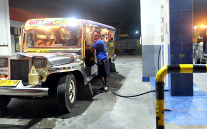 A gasoline boy fills the fuel of a jeepney on Monday night. Oil companies will increase their pump prices effective today because of the rising fuel prices in the global market. PNA