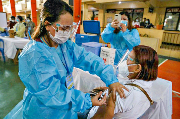 A health worker injects an “anti-coronavirus vaccine” to a woman during a vaccination simulation in Mandaluyong City on Jan. 27, 2021. JONATHAN CELLONA/ABS-CBN NEWS