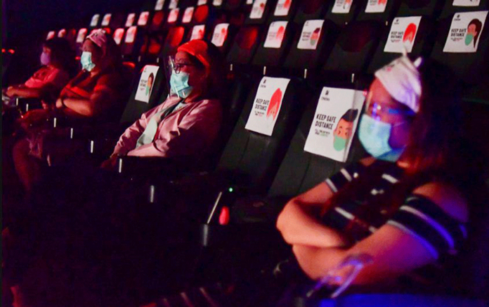 People in the cinema house follow safety protocols in watching a movie. The reopening of traditional movie houses in Metro Manila was moved to March 1 after Metro Manila mayors opposed the opening on Monday. MARK DEMAYO/ABS-CBN NEWS