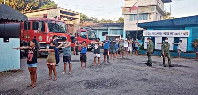 For not wearing facemasks, these residents of Silay City, Negros Occidental are made to march on the streets with their arms raised forward. The Commission on Human Rights describes this punishment as degrading.